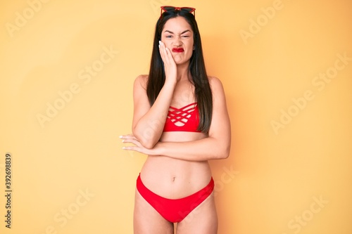 Young beautiful caucasian woman wearing bikini thinking looking tired and bored with depression problems with crossed arms.