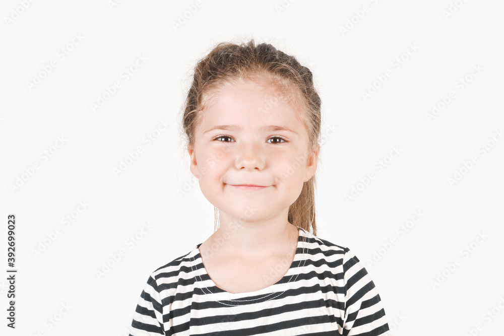 Smiling girl looking at camera. Smirking girl laughing inside and saying by her face I told you, I was right, I knew it. Portrait of posing little girl wearing striped shirt. Isolated background. Smiling girl looking at camera. Smirking girl laughing inside and saying by her face I told you, I was right, I knew it. Portrait of posing little girl wearing striped shirt. Isolated background.