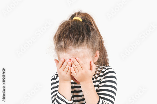 Cuadro en lienzo Crying girl with hands covering her face and head tilted forward down