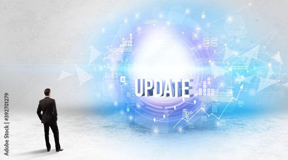 Rear view of a businessman standing in front of UPDATE inscription, modern technology concept Rear view of a businessman standing in front of UPDATE inscription, modern technology concept