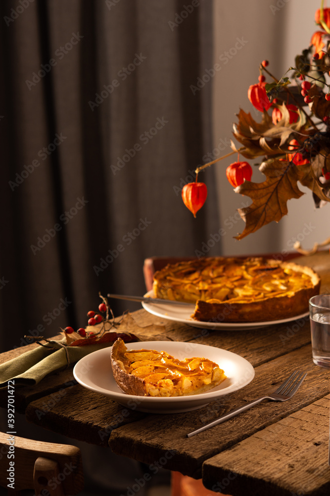 Apple pie with caramel on a wooden background, autumn bouquet in a vase, portion of pie in a plate close-up , autumn bouquet in a vase Apple pie with caramel on a wooden background, autumn bouquet in a vase, portion of pie in a plate close-up , autumn bouquet in a vase