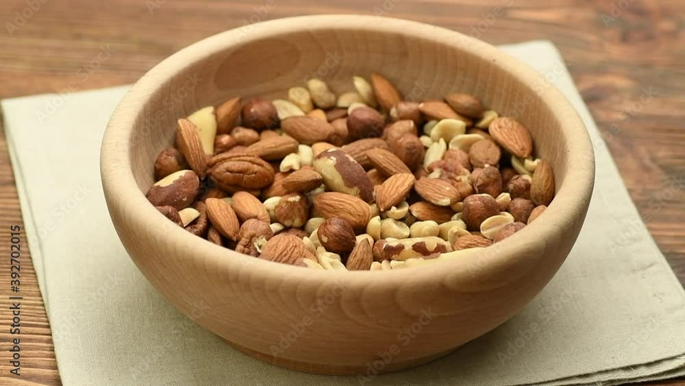 Mix of various nuts such as peanuts, almonds, pecan nuts, walnuts and Brazil nuts falling into a bowl, healthy snack concept, slow motion Mix of various nuts such as peanuts, almonds, pecan nuts, walnuts and Brazil nuts falling into a bowl, healthy snack concept, slow motion