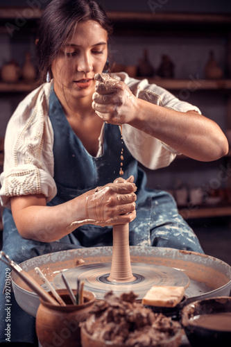 Processing clay ware and making dishes, process. Ceramics of handwork and clay ware on the potter's wheel. photo