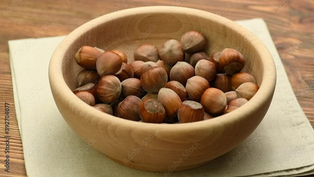 Hazelnuts falling into a wooden bowl, slow motion Hazelnuts falling into a wooden bowl, slow motion