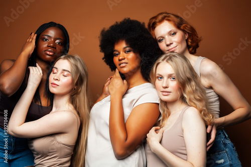 young pretty caucasian, afro, scandinavian woman posing cheerful together on brown background, lifestyle diverse nationality people concept