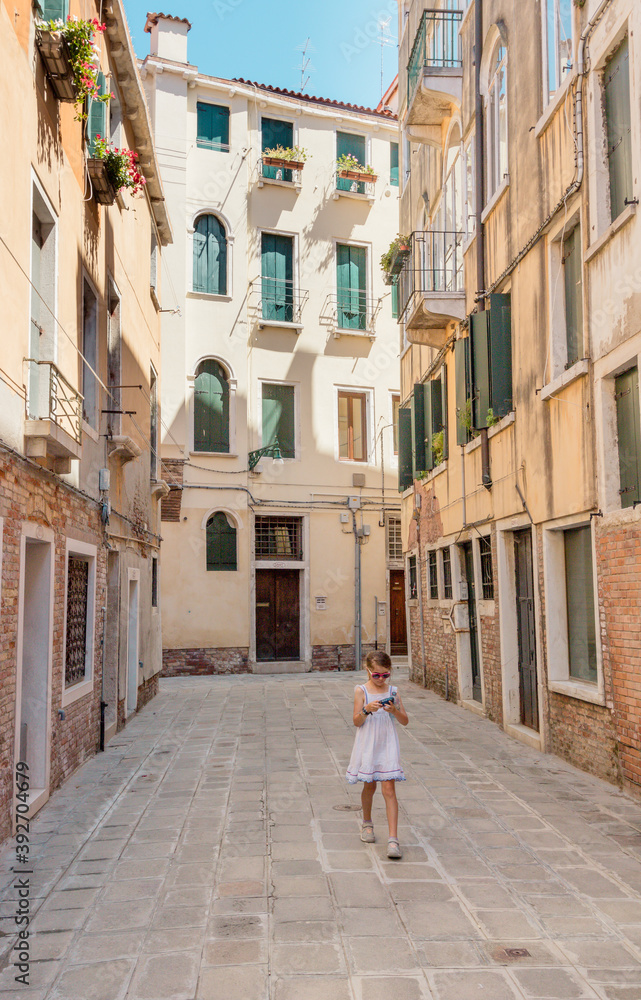 ruelle de Venise avec une fille tenant un appareil photo dans les mains