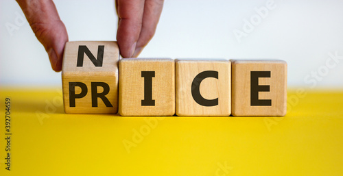 Nice price concept. Hand turns a cube and changes the word 'price' to 'nice'. Beautiful yellow table, white background. Business concept. Copy space.