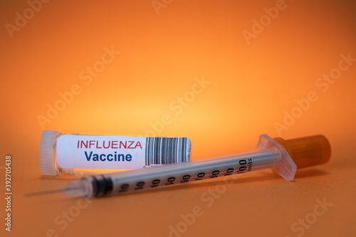 Inluenza Vaccine with Syringe on Orange Background photo