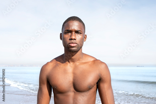 Portrait of young african boy with fitness body on the beach.