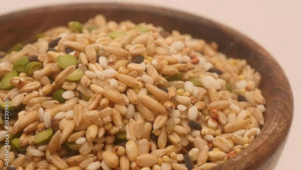 Detail rotation Healthy miscellaneous grains on a wooden bowl Detail rotation Healthy miscellaneous grains on a wooden bowl