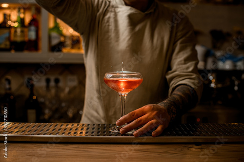 view on wine glass with splashes of bright cocktail which stands on the bar counter.