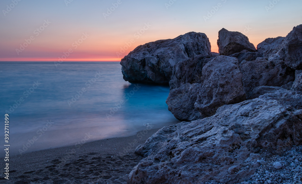 Sunset photo of beautiful Kathisma beach, Lefkada, Ionian islands, Greece. Long exposure beach photo with rocky background during sunset. Rock formation. Sunset photo of beautiful Kathisma beach, Lefkada, Ionian islands, Greece. Long exposure beach photo with rocky background during sunset. Rock formation.