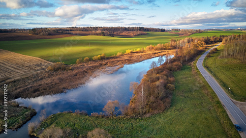 Obraz na płótnie Beautiful green field. Winter crops. Lake with blue sky reflection w salonie
