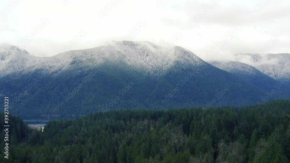 Aerial of snowy canadian mountain and green forest Aerial of snowy canadian mountain and green forest
