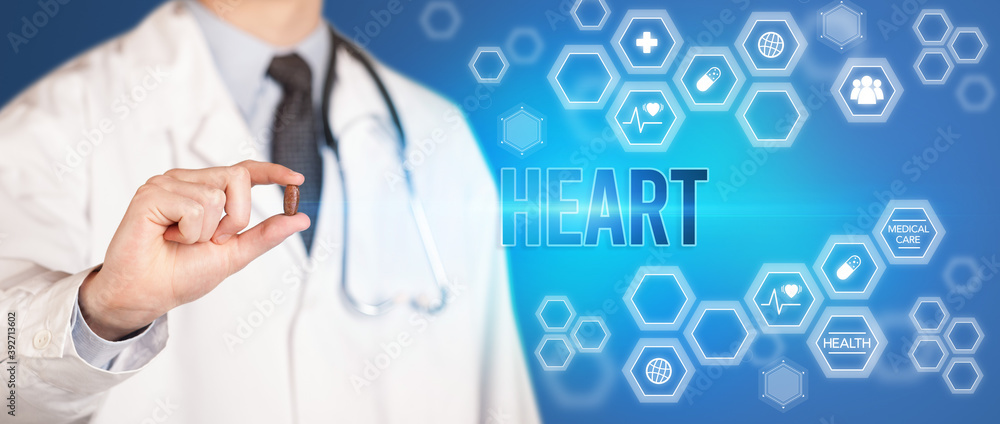 Close-up of a doctor giving you a pill with HEART inscription, medical concept Close-up of a doctor giving you a pill with HEART inscription, medical concept