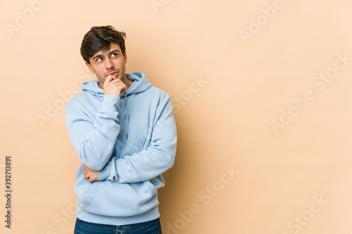 Young cool man relaxed thinking about something looking at a copy space.