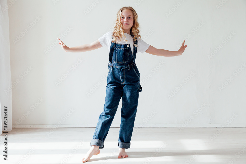 portrait of a beautiful blonde girl in a denim jumpsuit