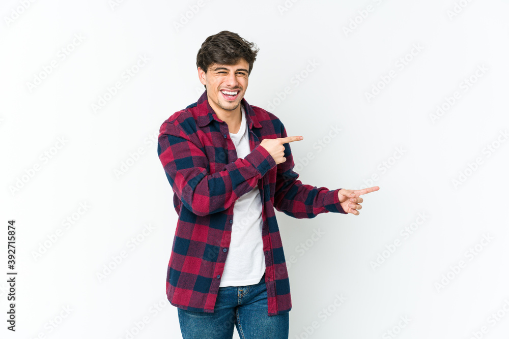 Young cool man pointing with forefingers to a copy space, expressing excitement and desire. Young cool man pointing with forefingers to a copy space, expressing excitement and desire.