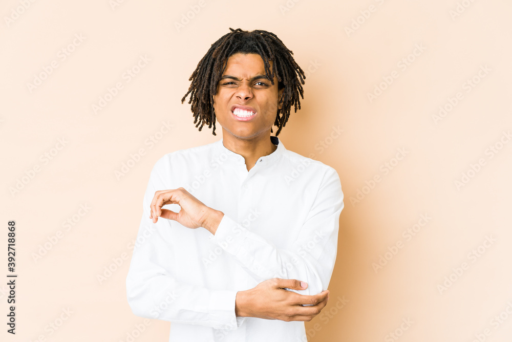 Young african american rasta man massaging elbow, suffering after a bad movement. Young african american rasta man massaging elbow, suffering after a bad movement.