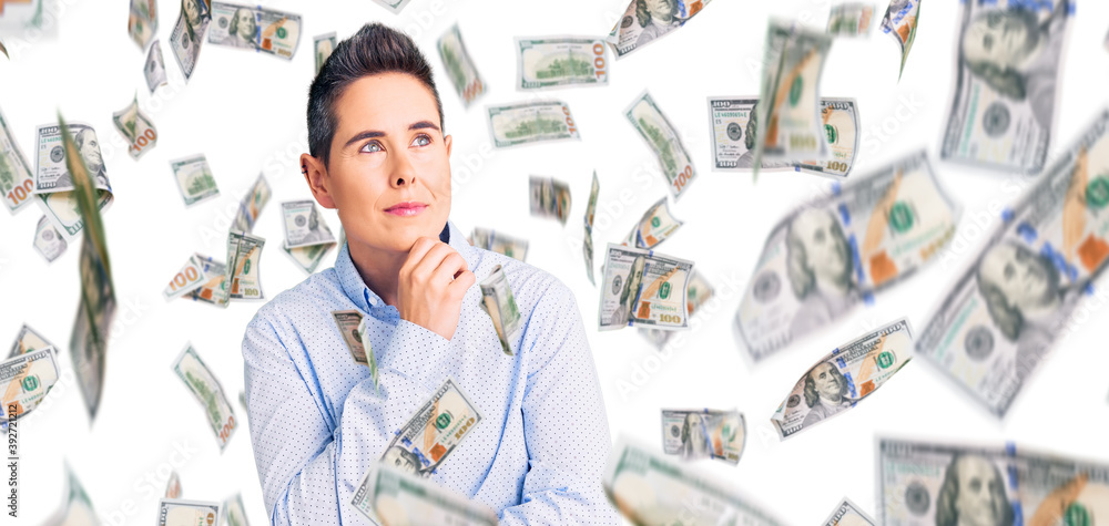 Young woman with short hair wearing business clothes with hand on chin thinking about question, pensive expression. smiling with thoughtful face. doubt concept. Young woman with short hair wearing business clothes with hand on chin thinking about question, pensive expression. smiling with thoughtful face. doubt concept.