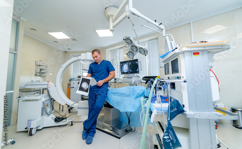 Male doctor in surgery room with modern medical equipment. Hospital room ready for operation.