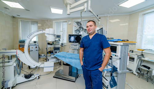 Doctor on operating room background. Modern interior of up to date surgery room.