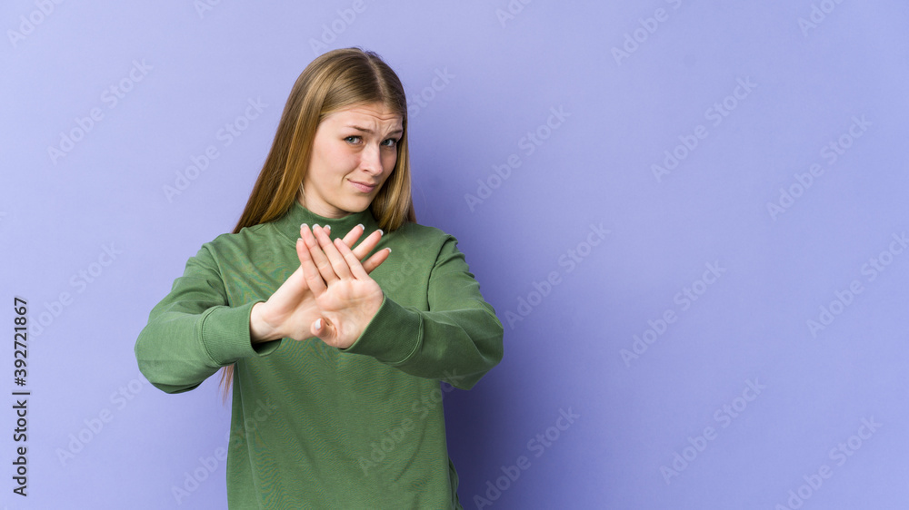 Young blonde woman isolated on purple background doing a denial gesture Young blonde woman isolated on purple background doing a denial gesture