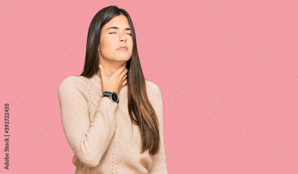 Young brunette woman wearing casual winter sweater touching painful neck, sore throat for flu, clod and infection Young brunette woman wearing casual winter sweater touching painful neck, sore throat for flu, clod and infection