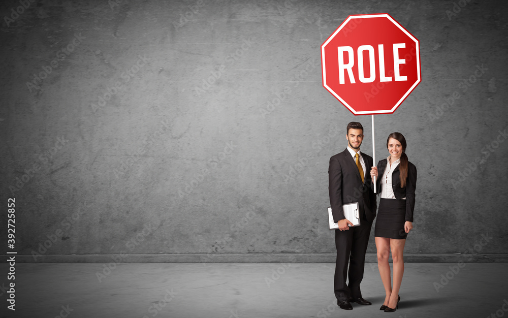 Obraz premium Young business person holding road sign with ROLE inscription, new rules concept