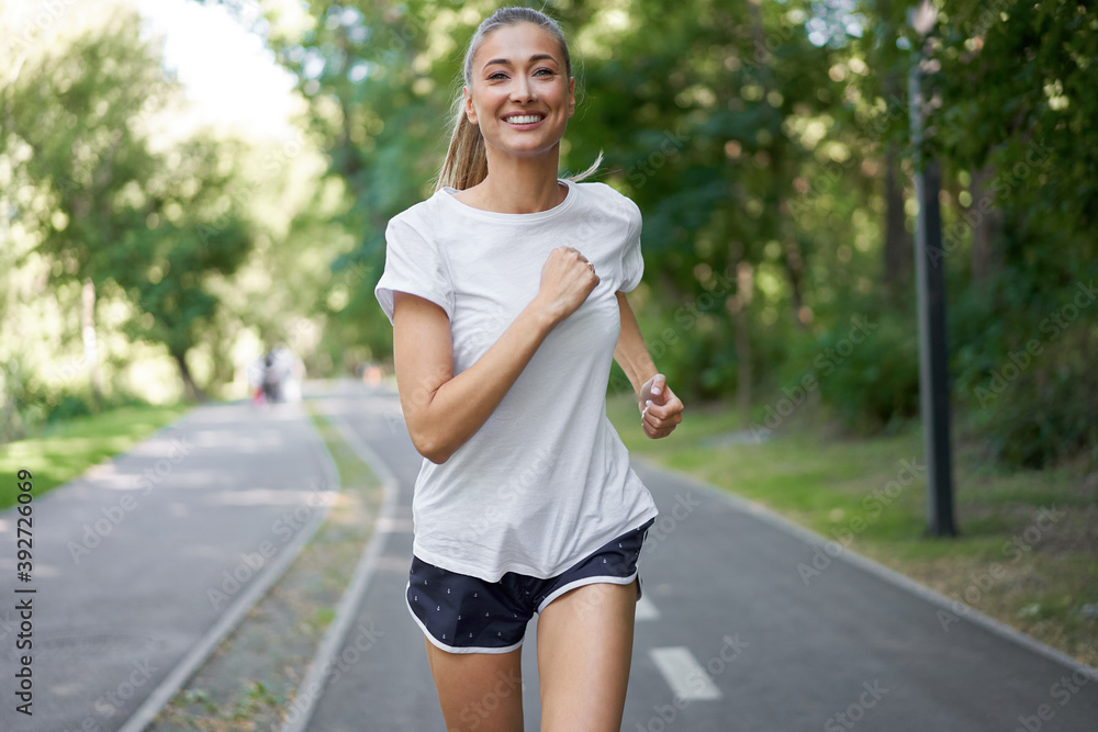 Woman running asphalt road summer park Woman running asphalt road summer park