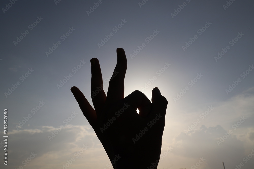 silhouette of a hand showing fine or perfect sign on the sky