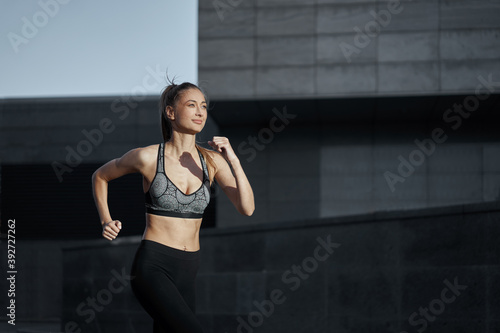 Woman running urban city street background
