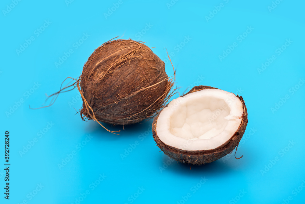 Coconut cracked floors on the blue background. Minimalism. Creative concept of nutrition.