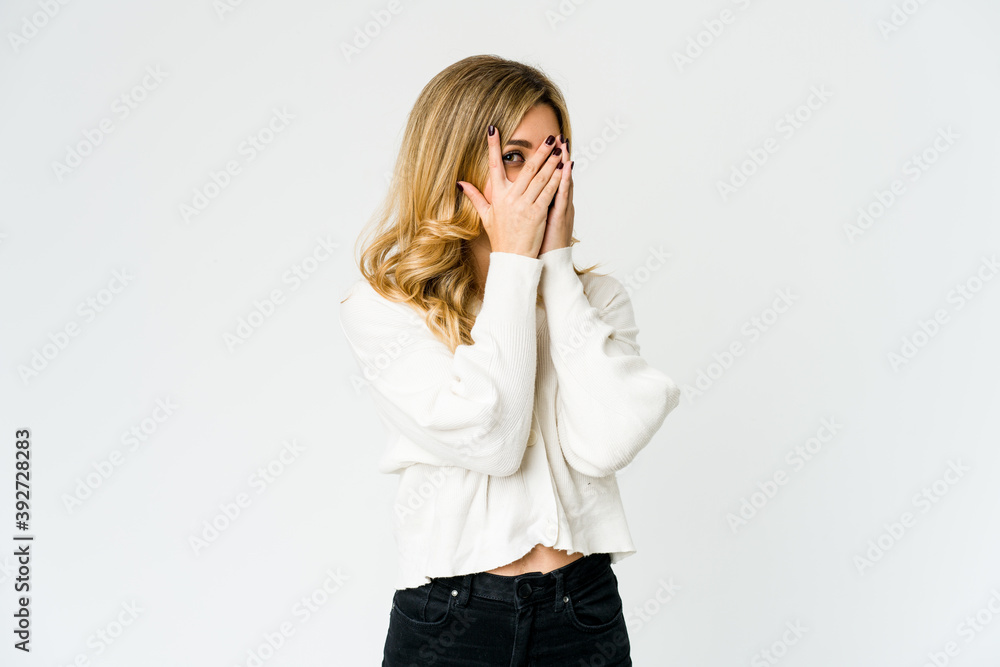 Young caucasian blonde woman blink through fingers frightened and nervous. Young caucasian blonde woman blink through fingers frightened and nervous.