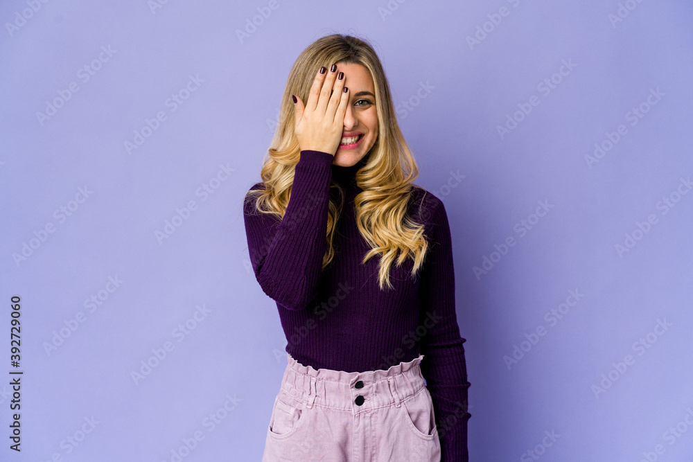 Young caucasian blonde woman having fun covering half of face with palm. Young caucasian blonde woman having fun covering half of face with palm.