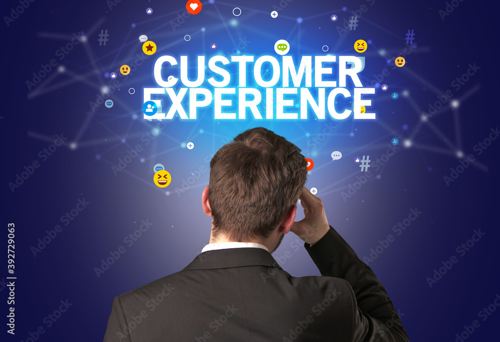 Rear view of a businessman with CUSTOMER EXPERIENCE inscription, social networking concept Rear view of a businessman with CUSTOMER EXPERIENCE inscription, social networking concept