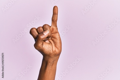 фотографія Arm and hand of black middle age woman over pink isolated background showing lit
