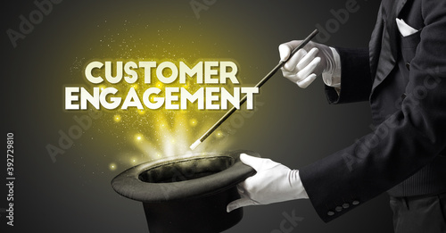 Illusionist is showing magic trick with CUSTOMER ENGAGEMENT inscription, new business model concept