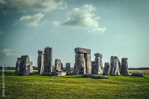 Stonehenge ancient ruins on Sailbury Plain in the UK standing under strange turqoise sky with long shadows