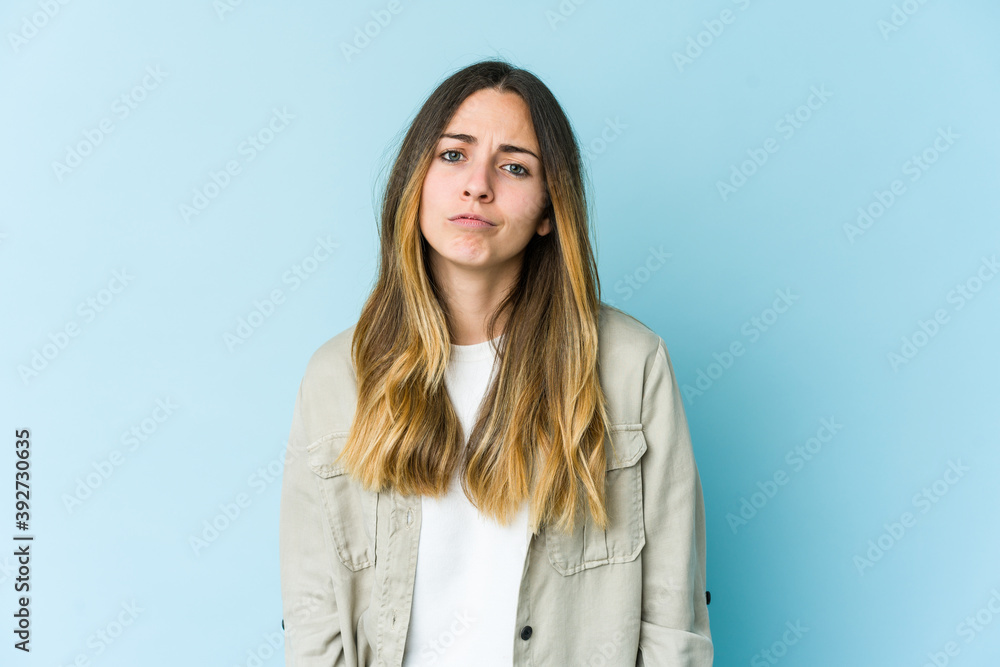 Young caucasian woman isolated on blue background sad, serious face, feeling miserable and displeased. Young caucasian woman isolated on blue background sad, serious face, feeling miserable and displeased.