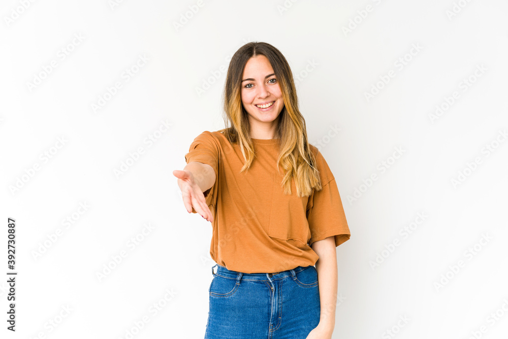 Young caucasian woman isolated on white background stretching hand at camera in greeting gesture. Young caucasian woman isolated on white background stretching hand at camera in greeting gesture.