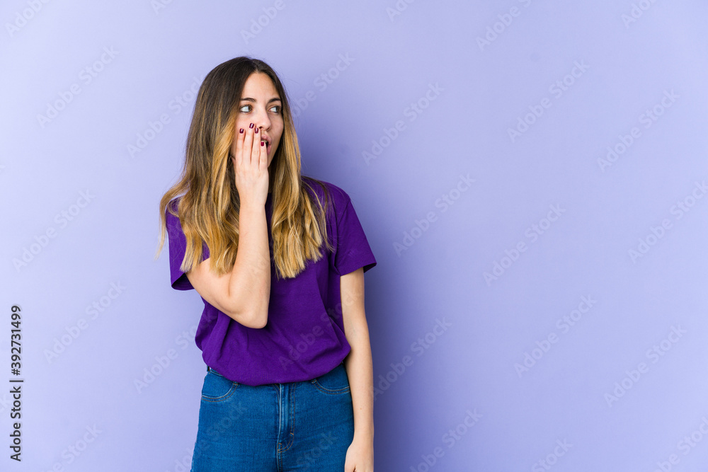 Young caucasian woman isolated on purple background being shocked because of something she has seen. Young caucasian woman isolated on purple background being shocked because of something she has seen.
