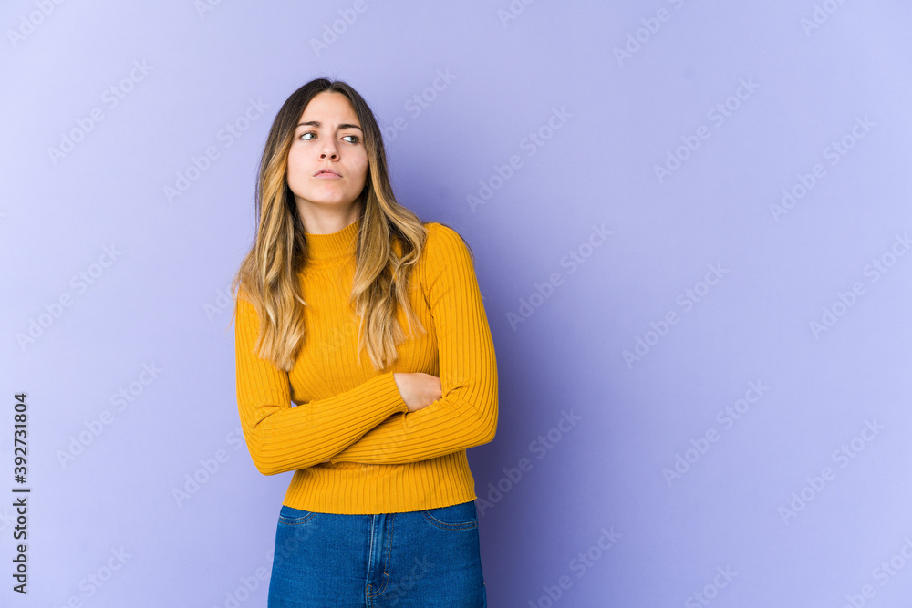 Young caucasian woman isolated on purple background tired of a repetitive task. Young caucasian woman isolated on purple background tired of a repetitive task.
