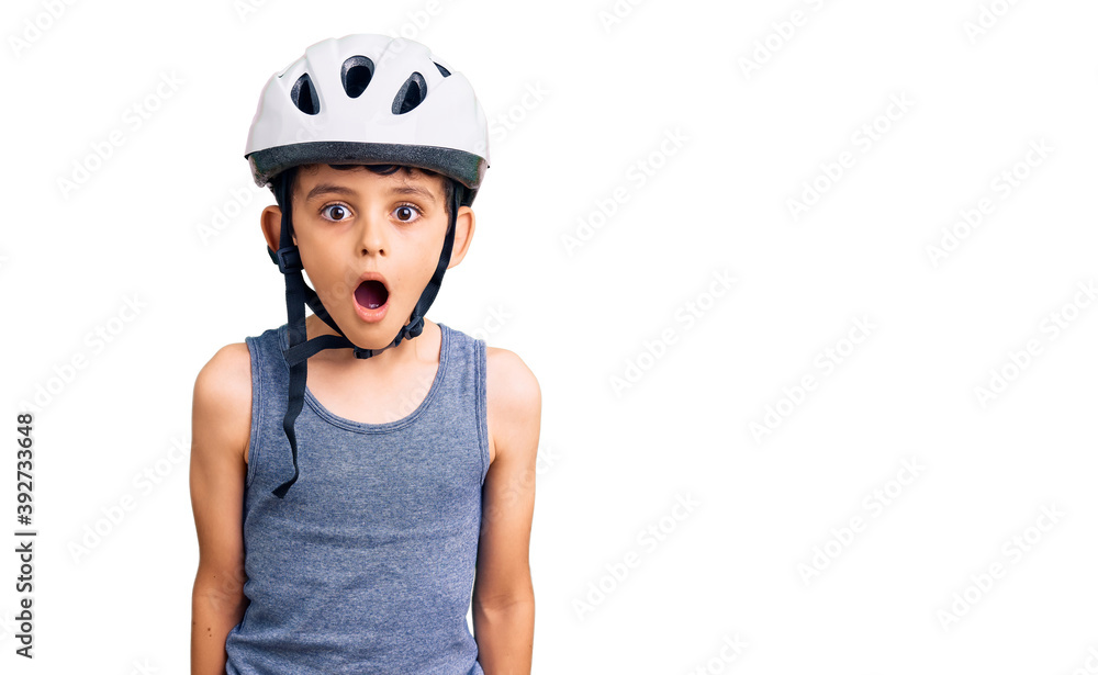Little cute boy kid wearing bike helmet scared and amazed with open mouth for surprise, disbelief face Little cute boy kid wearing bike helmet scared and amazed with open mouth for surprise, disbelief face
