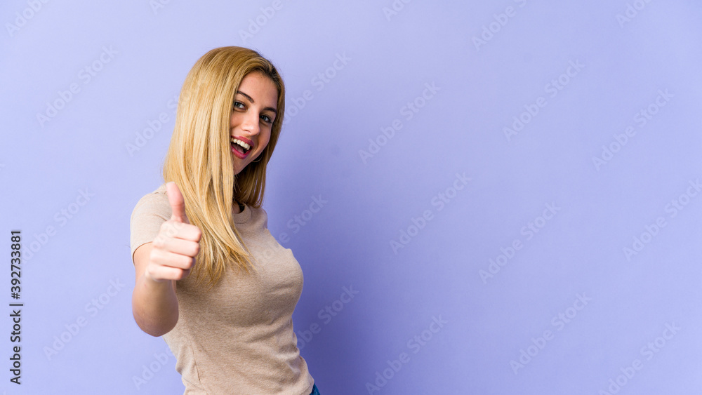 Young blonde caucasian woman smiling and raising thumb up