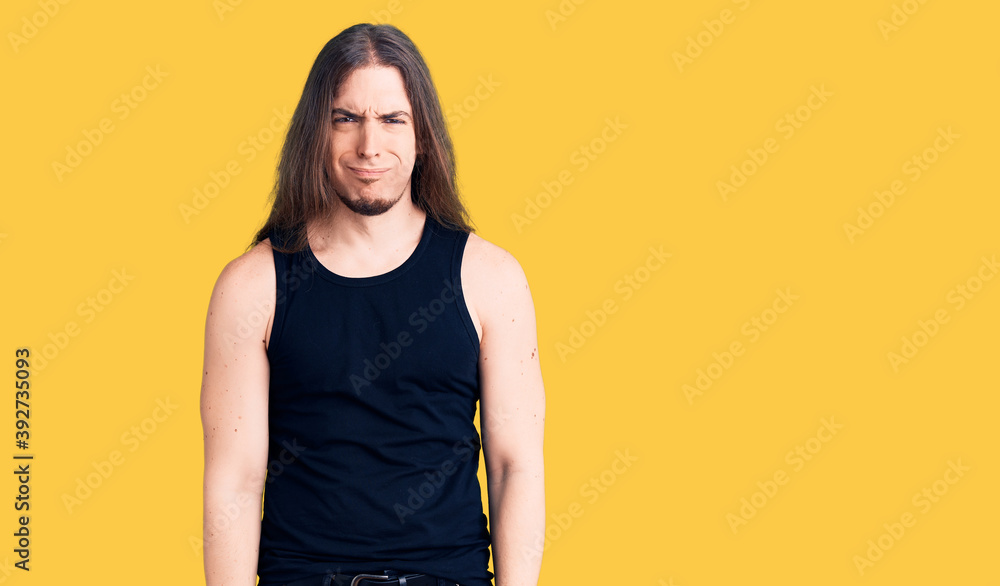Young adult man with long hair wearing goth style with black clothes depressed and worry for distress, crying angry and afraid. sad expression. Young adult man with long hair wearing goth style with black clothes depressed and worry for distress, crying angry and afraid. sad expression.