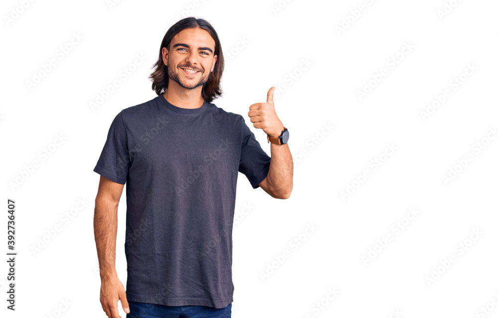 Young handsome man wearing casual clothes smiling happy and positive, thumb up doing excellent and approval sign Young handsome man wearing casual clothes smiling happy and positive, thumb up doing excellent and approval sign