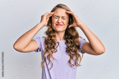 Young blonde girl wearing casual clothes with hand on head, headache because stress. suffering migraine.