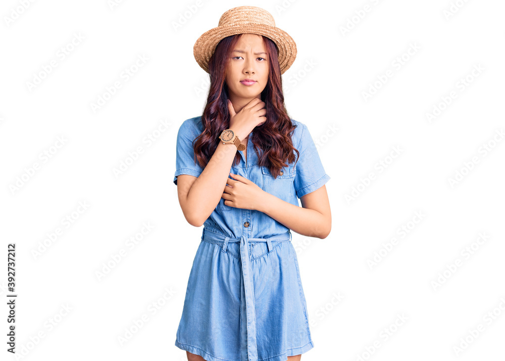 Young beautiful chinese girl wearing summer hat touching painful neck, sore throat for flu, clod and infection Young beautiful chinese girl wearing summer hat touching painful neck, sore throat for flu, clod and infection