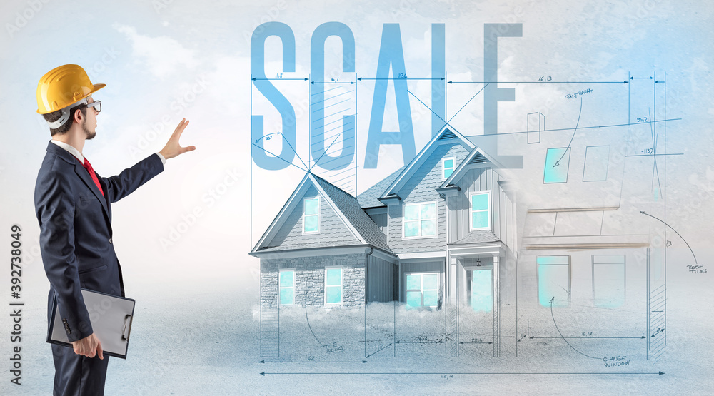 Young engineer holding blueprint with SCALE inscription, house planning concept Young engineer holding blueprint with SCALE inscription, house planning concept